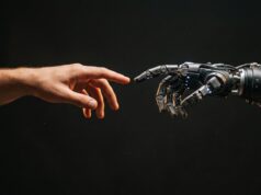 Una mano humana se acerca a una mano robótica, imagen que representa la interacción entre las personas y la inteligencia artificial.